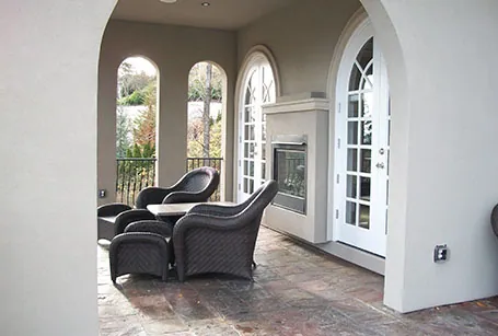 Sunroom with arched French doors and a fireplace