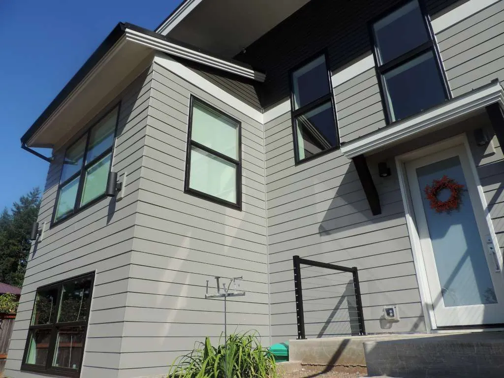 Entry with grey lap siding and black-framed windows
