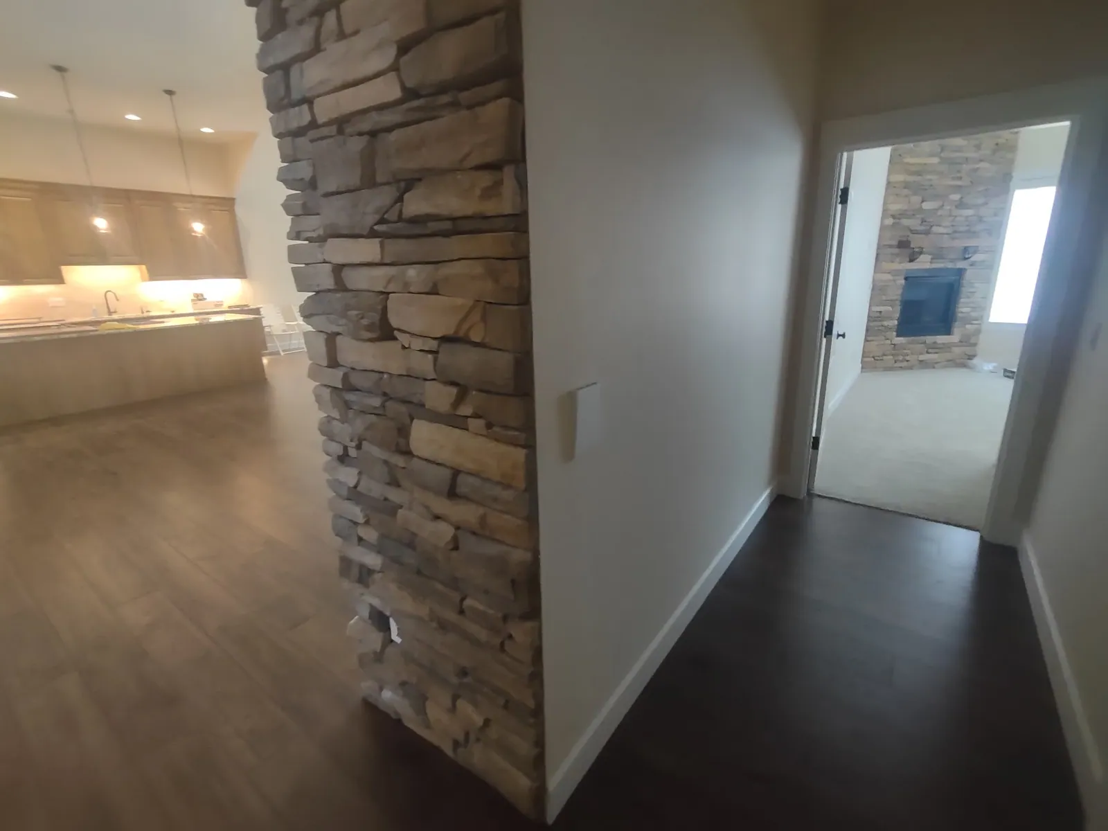 Hallway with a stacked stone column looking into the main bedroom