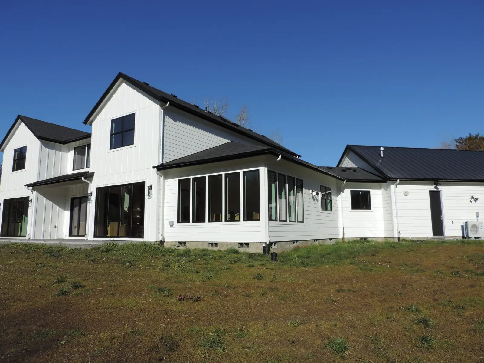 White board-and-batten custom farmhouse with black-framed windows