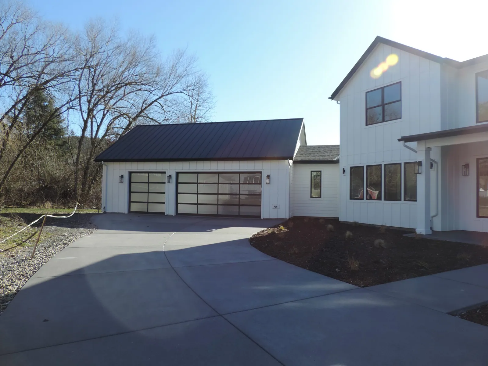Detached garage with glass doors and a new concrete drive