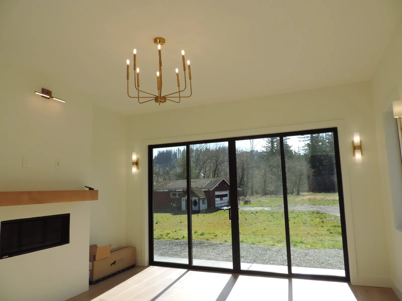 Living room with fireplace, brass chandelier and sliding doors