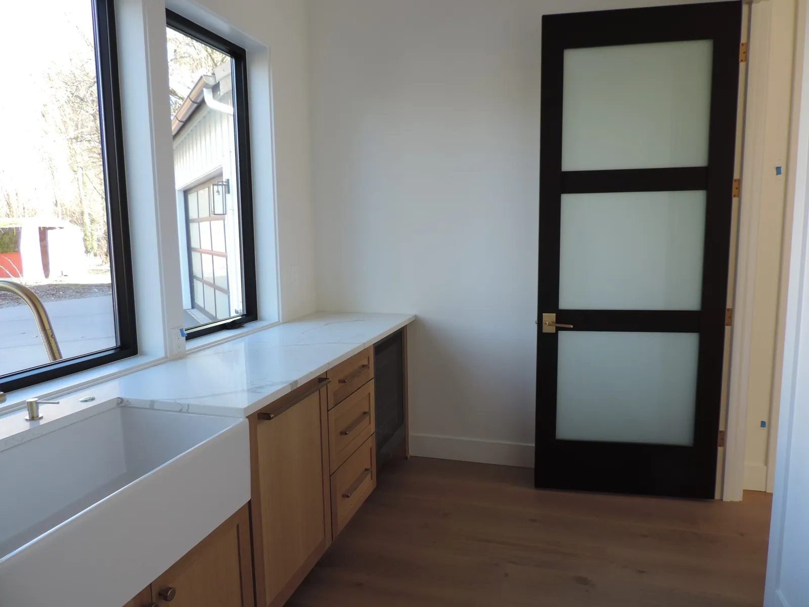 Pantry behind a black-framed frosted glass door