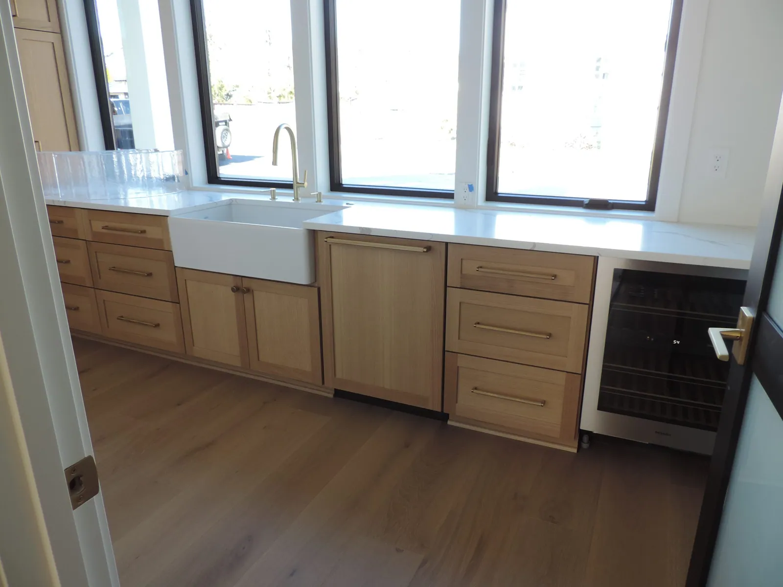 Sink wall with farmhouse sink under black-framed windows