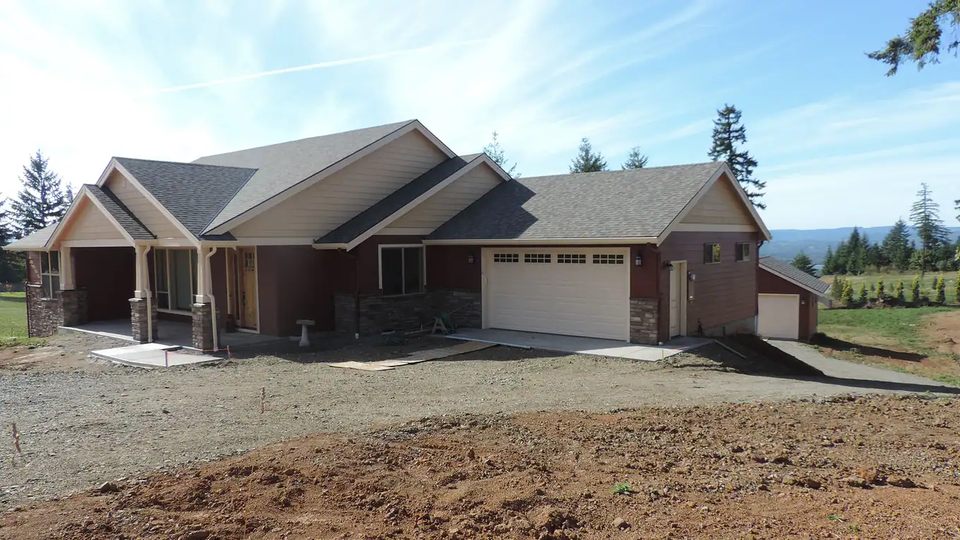 Single-story home with a white garage door, before landscaping