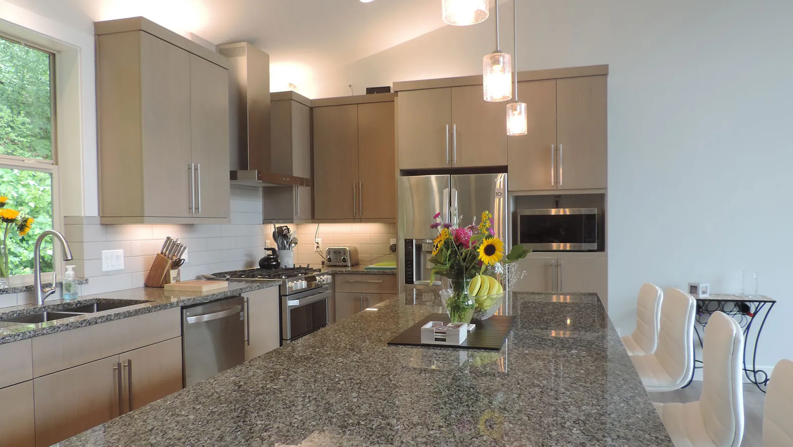 Modern kitchen with flat-panel cabinets, stainless appliances and a granite island